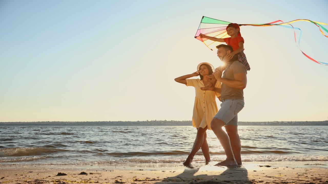 Familia con una cometa en la playa