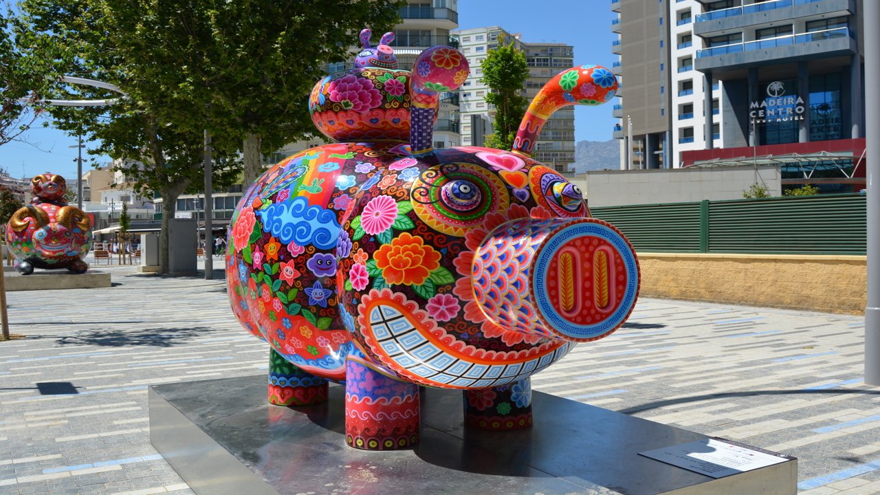 Figura de un cerdo de colores en un parque