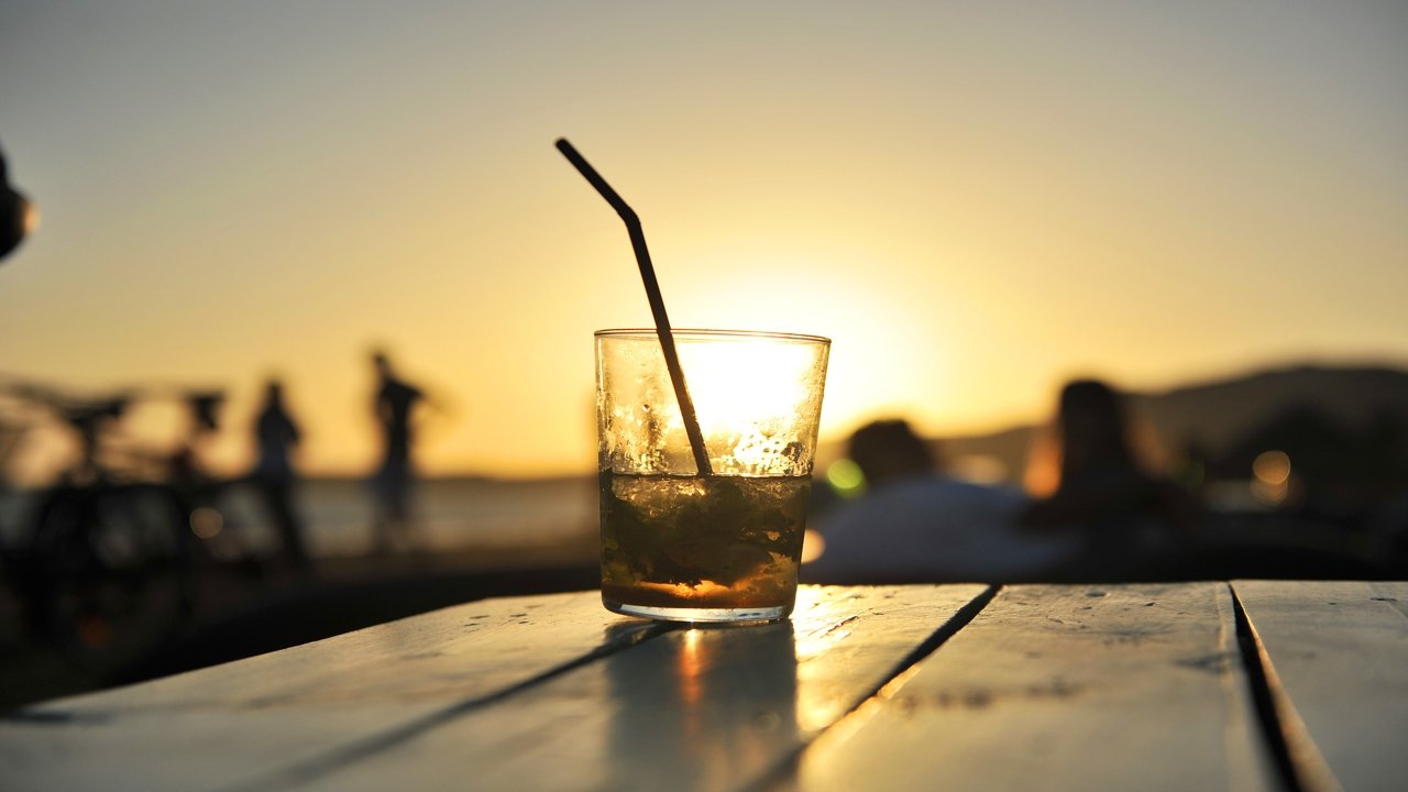 Vaso en la mesa del chiringuito al atardecer