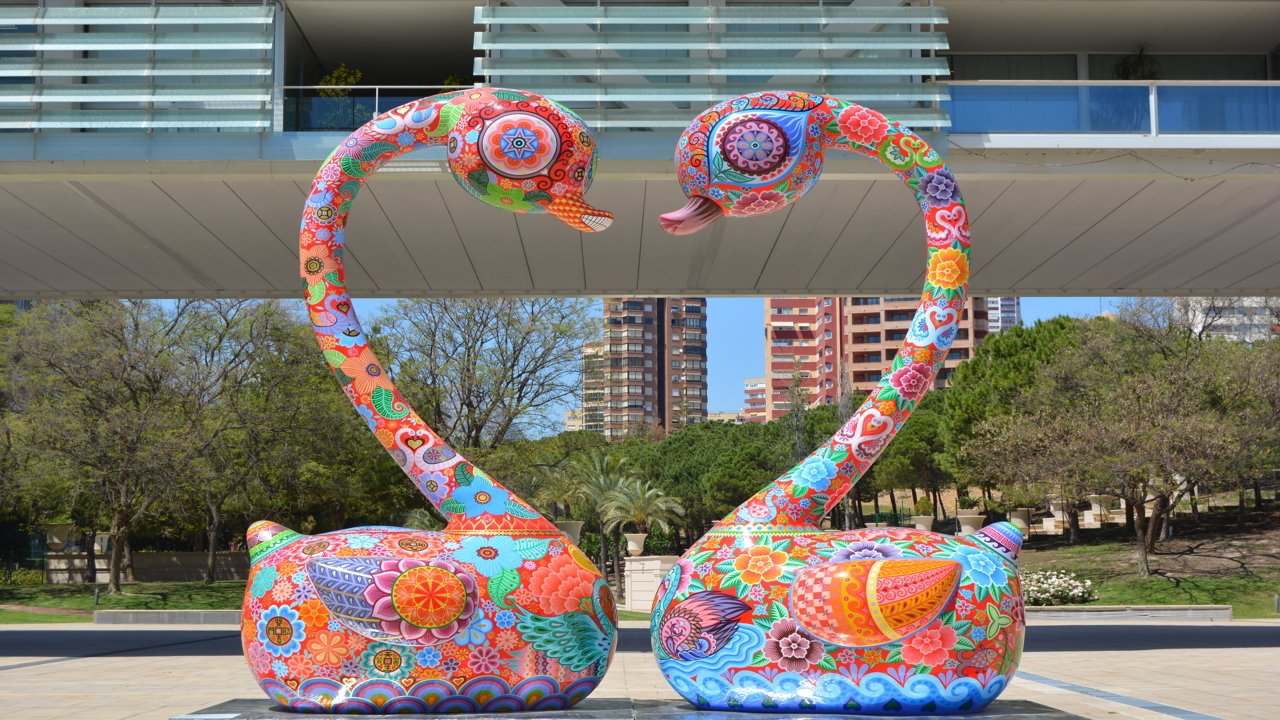 Figuras de dos cisnes de colores en un parque