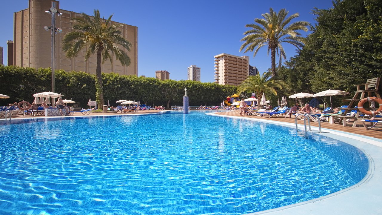Piscina grande rodeada de sombrillas