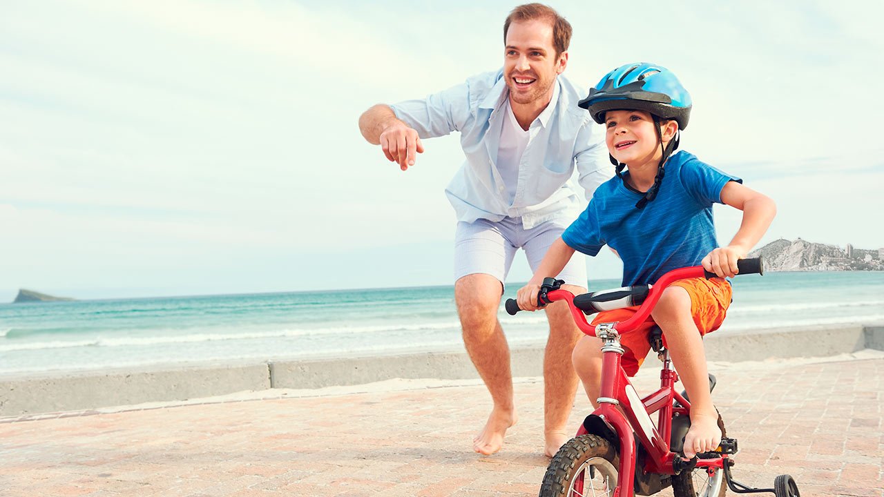 Niño bicicleta playa