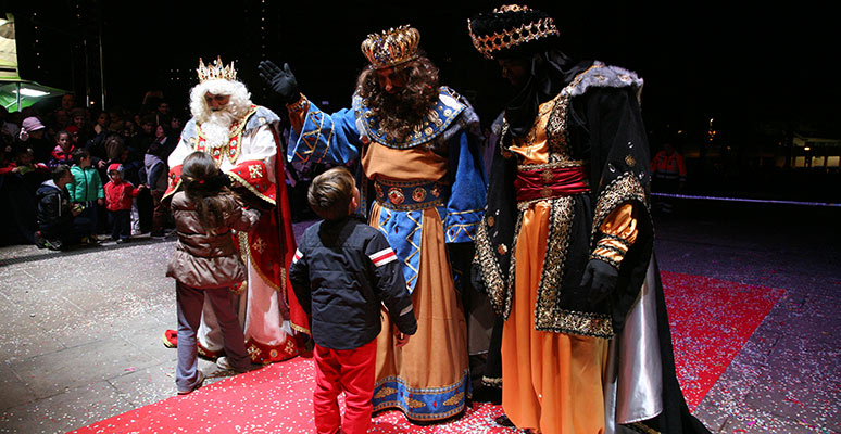 Los reyes magos saludando a los niños